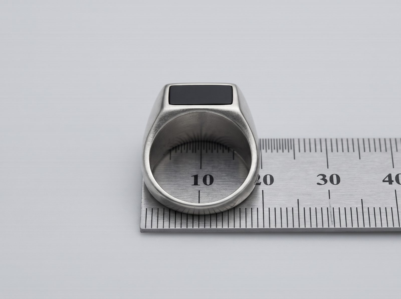 Measuring the inside diameter of a men's silver ring on a millimetre ruler